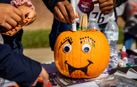 pumpkin being decorated with paint and sequins