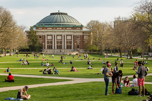 Foellinger Auditorium on a spring day. The main quad is filled with students engaged in various activities.