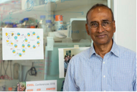 Photo of Professor Venki Ramakrishnan. He's standing in front of a lab window and is wearing blue, button-down shirt and glasses.
